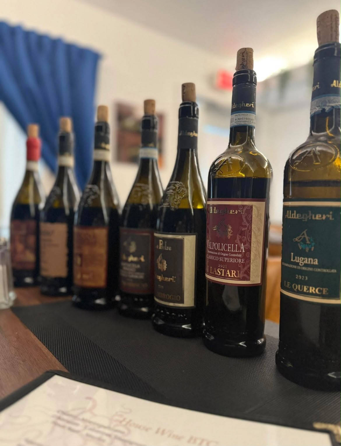 Lineup of Italian wine bottles on a restaurant table